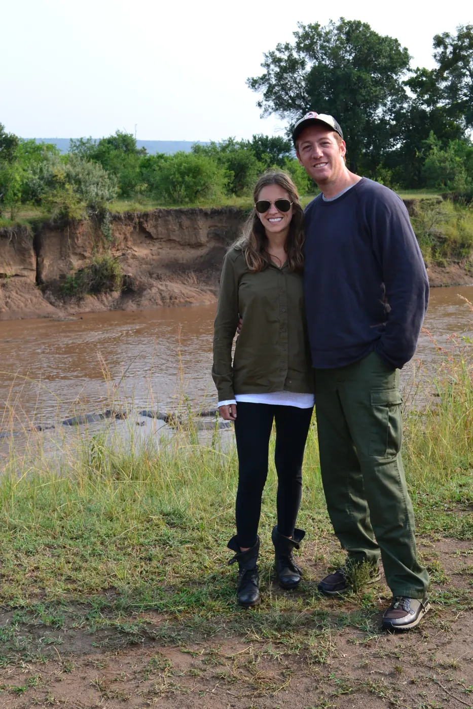 A newlywed couple standing on the bank of the Mara River in Kenya
